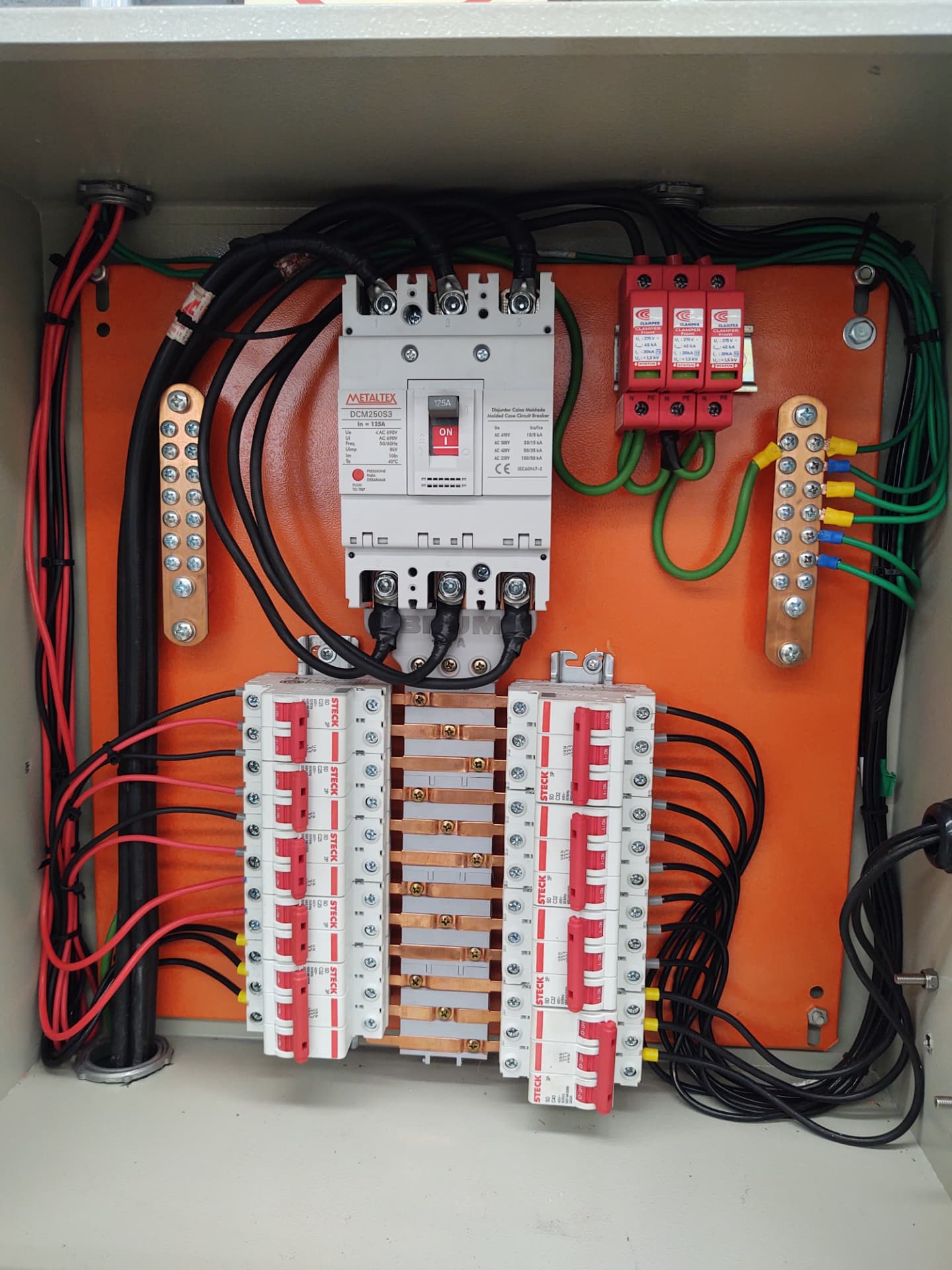 Quadro de distribuição montado com disjuntores e cabeamento organizado
